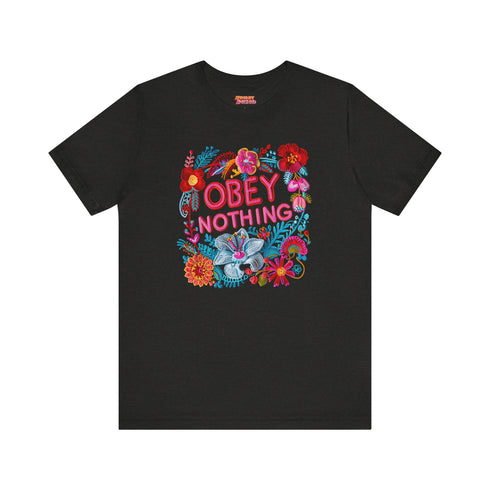 Black activist T-shirt with a floral embroidered-style design and the words “Obey Nothing” in bold, bright lettering.